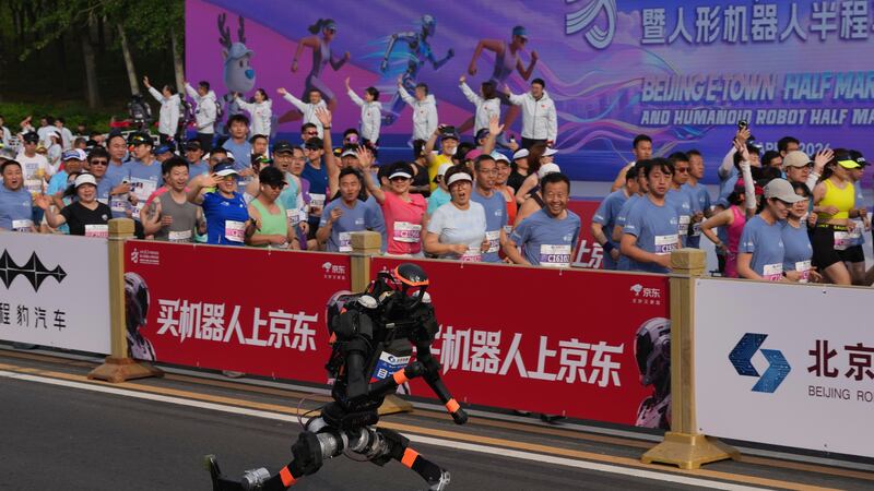 Un robot comienza a correr al lado de los corredores humanos para la II Media Maratón y Media...
