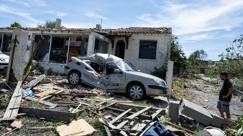 A resident watches a damaged house after a tornado ravaged the small village of Pomas in...