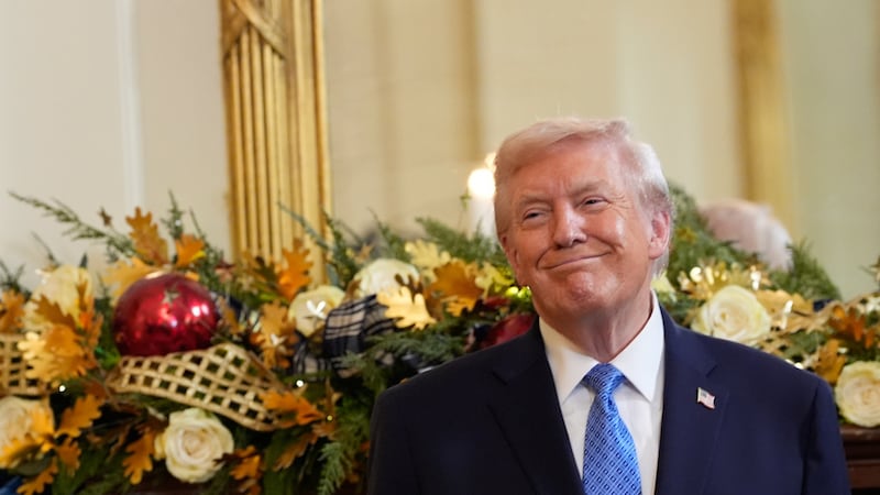 President Donald Trump smiles during a Hanukkah reception in the East Room of the White House,...
