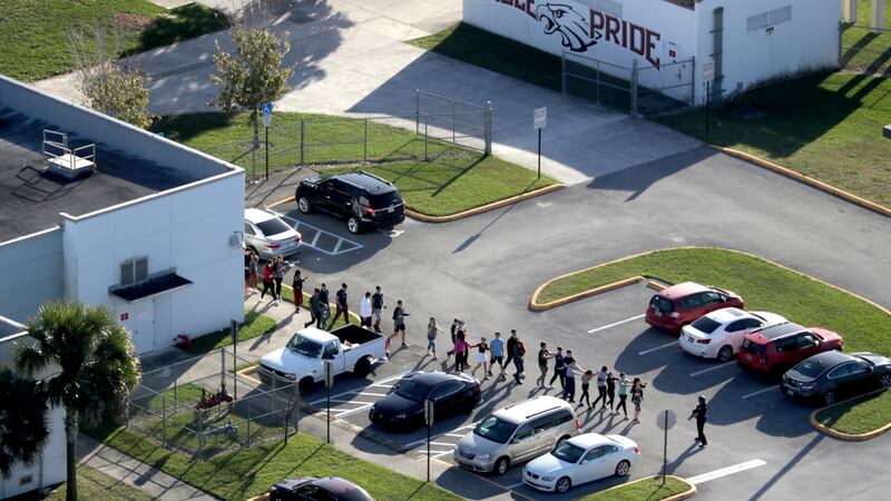 In this Feb. 14 file photo. students are evacuated by police from Marjory Stoneman Douglas...