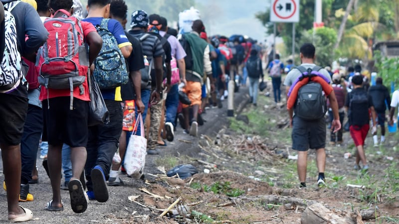 Migrantes caminan por la carretera que atraviesa el municipio de Huehuetán, estado de Chiapas,...