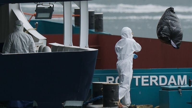 Varias personas con equipo protector retiran desechos del crucero MV Hondius tras su arribo al...