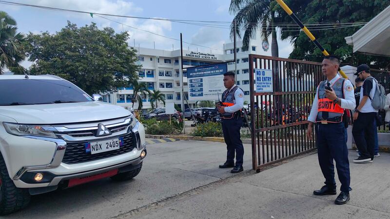 Guardias de seguridad observan la salida de vehículos de la Universidad Ateneo de Zamboanga...