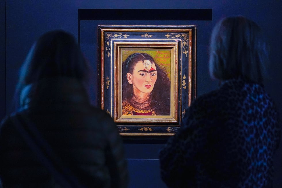 ARCHIVO - Los visitantes observan la pintura de Frida Kahlo titulada "Diego y yo", expuesta en...