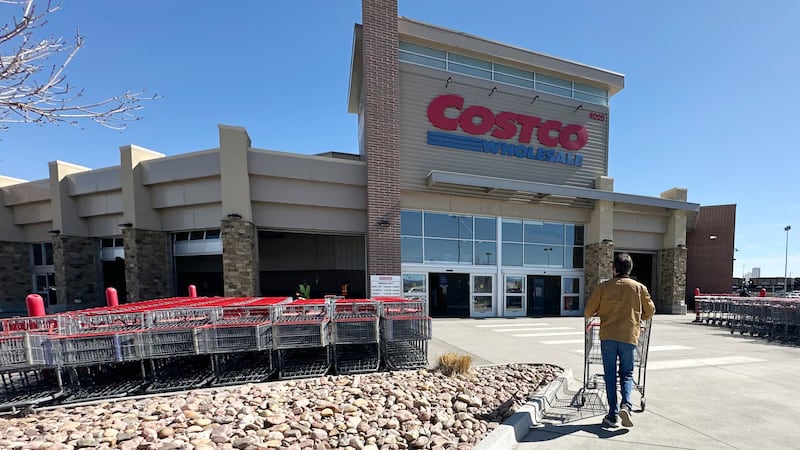ARCHIVO – Un comprador solitario empuja un carrito hacia la entrada de un almacén de Costco,...