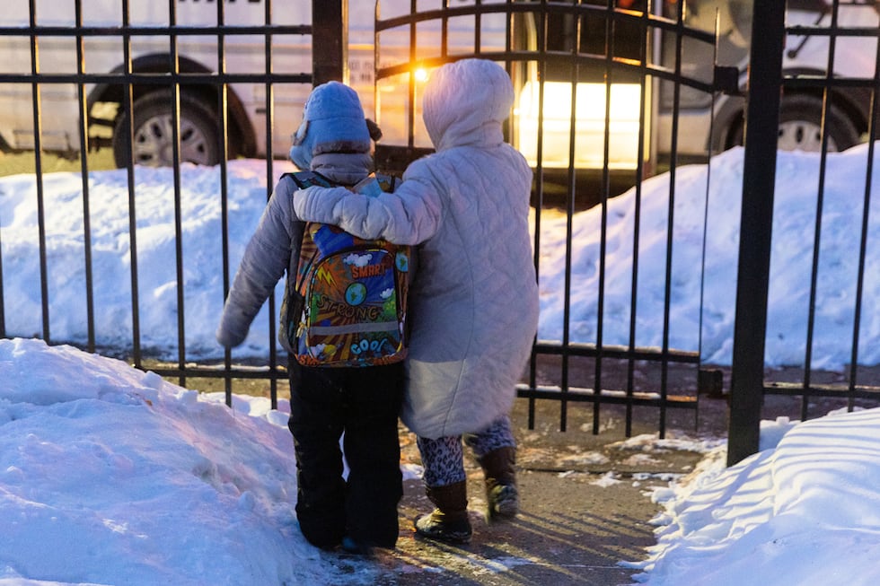 Giancarlo, de 10, es escoltado por su madre hasta la entrada de su casa para subir al bus...