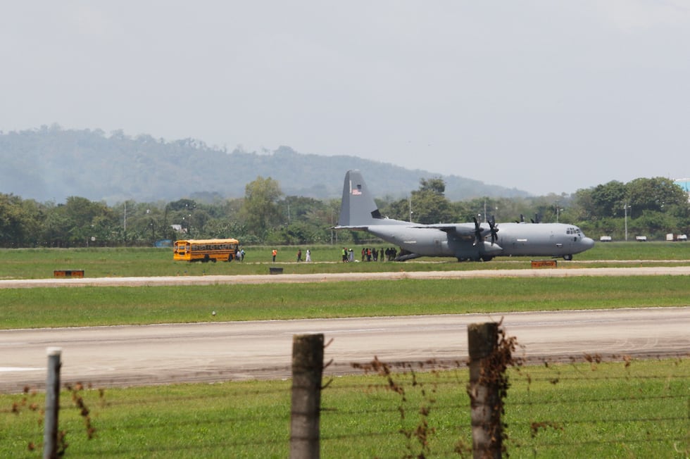 Migrantes deportados de Estados Unidos caminan hacia un autobús que los espera tras...