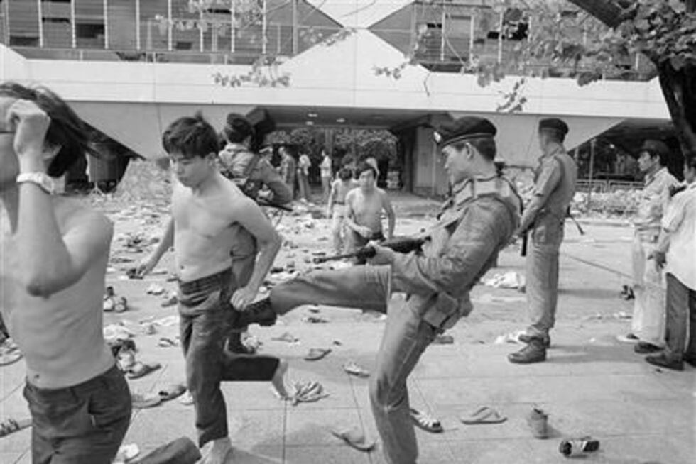 Un policía le da un puntapié a un estudiante capturado durante una batalla campal entre las...