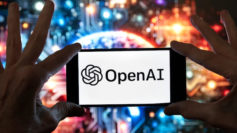 FILE - The OpenAI logo is displayed on a cell phone in front of an image generated by...